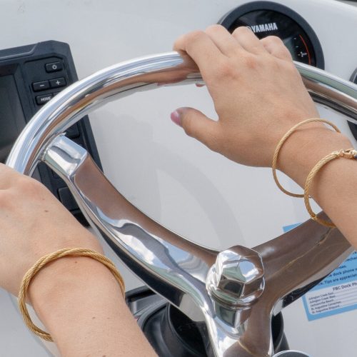 Hands on a Boat Wheel showing off jewelry
